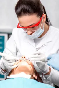 dental hygienist performing preventative dentistry services on a female patient at Steven P Ellinwood DDS in Fort Wayne IN