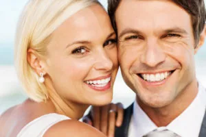 Close-up portrait of loving newlywed couple smiling after their smile makeover by Steven P Ellinwood DDS in Fort Wayne IN