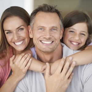 A young girl with her parents smiling after their dental visit with Steven Ellinwood DDS in Fort Wayne IN